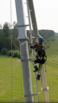 A person climbing a metal pole