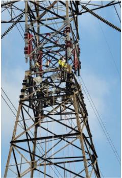 A high voltage tower with workers on it  